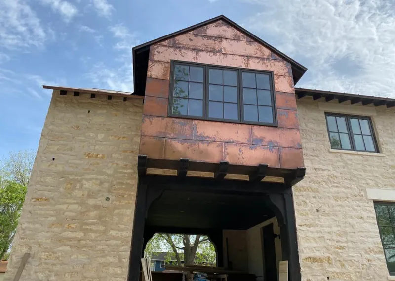 Copper metal panel facade on a stone building for Metal Roof Coating in Sterling